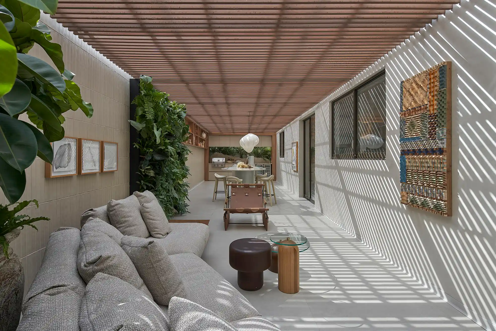 Manuela Senna - Varanda “Sementes Casa Ferolla”. Projeto da CASACOR Minas Gerais 2023. Na foto, varanda gourmet com cozinha, teto ripado, churrasqueira e plantas.